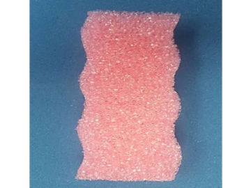 Pink textured sponge on blue background