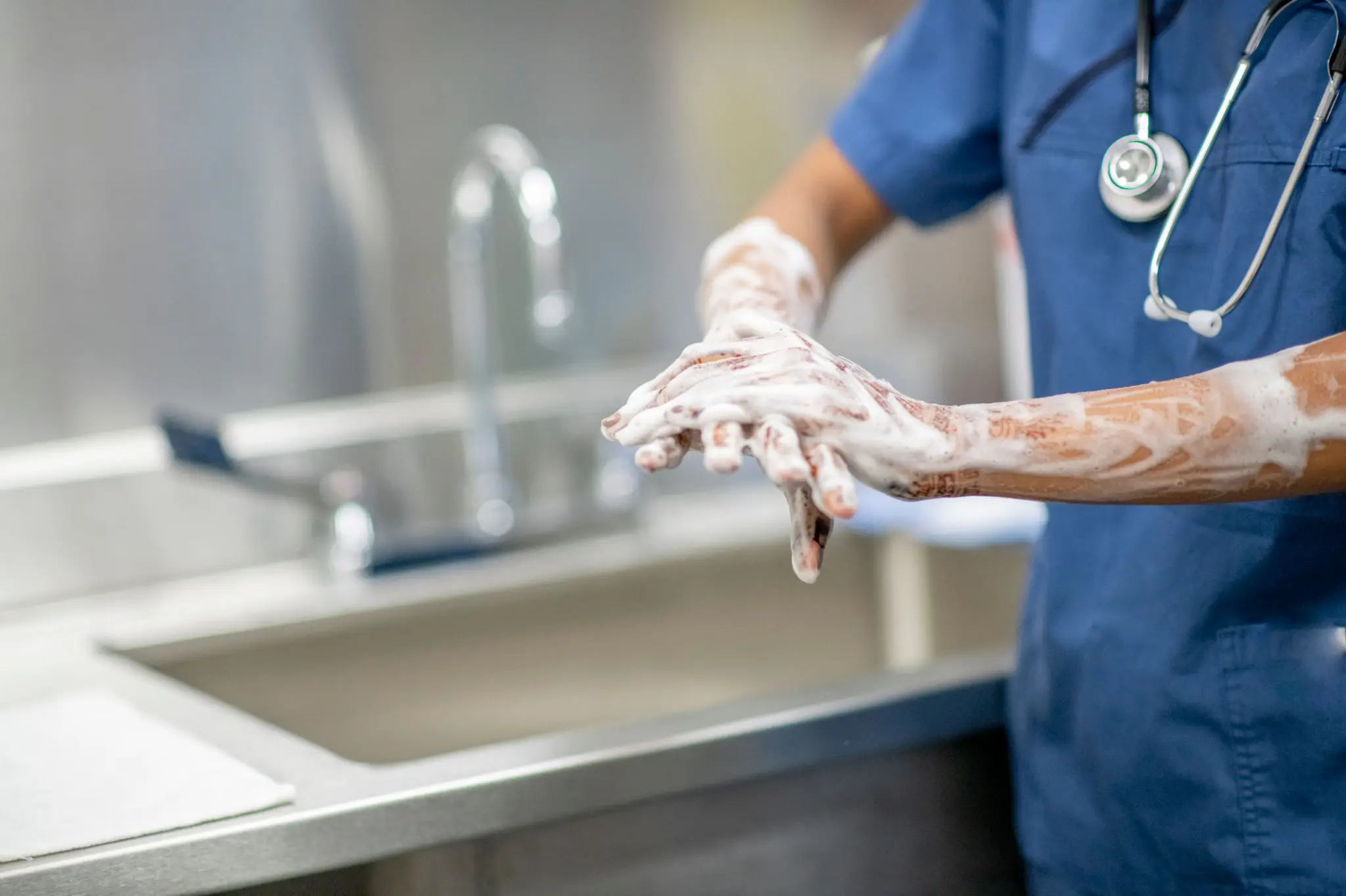 A healthcare worker washing hands thoroughly with soap.